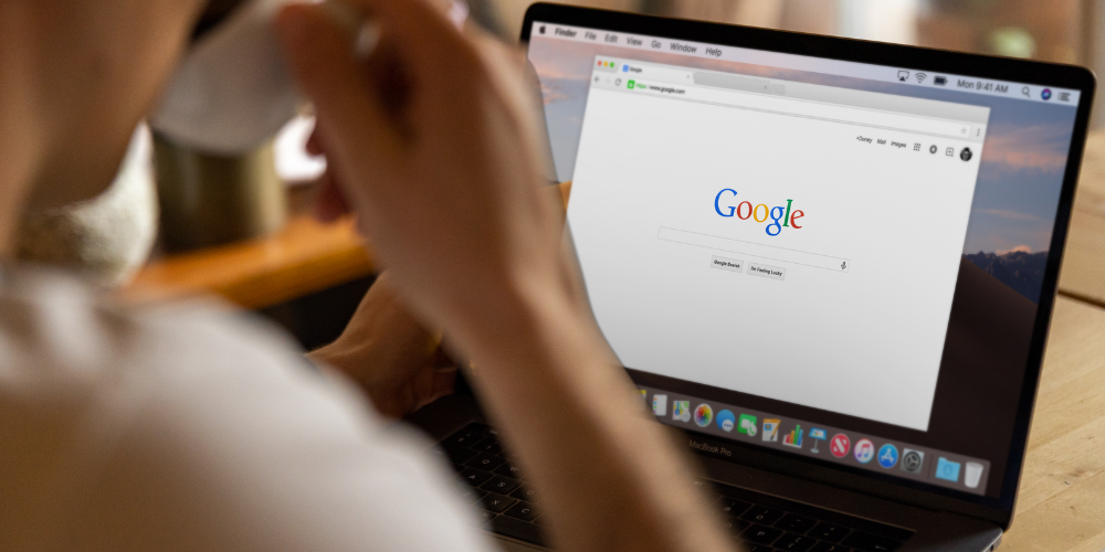 Persona sentada frente a un ordenador portátil buscando en Google